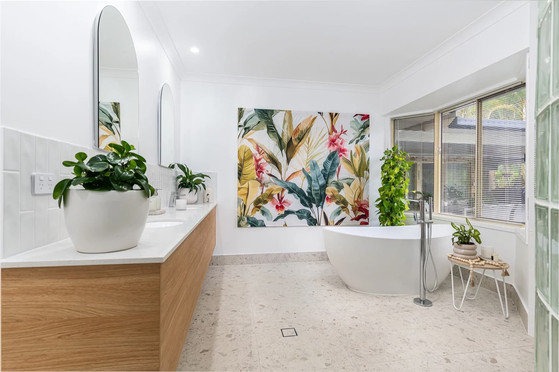 Renovated Karalee bathroom with a freestanding tub, twin-basin floating vanity and arched mirrors.
