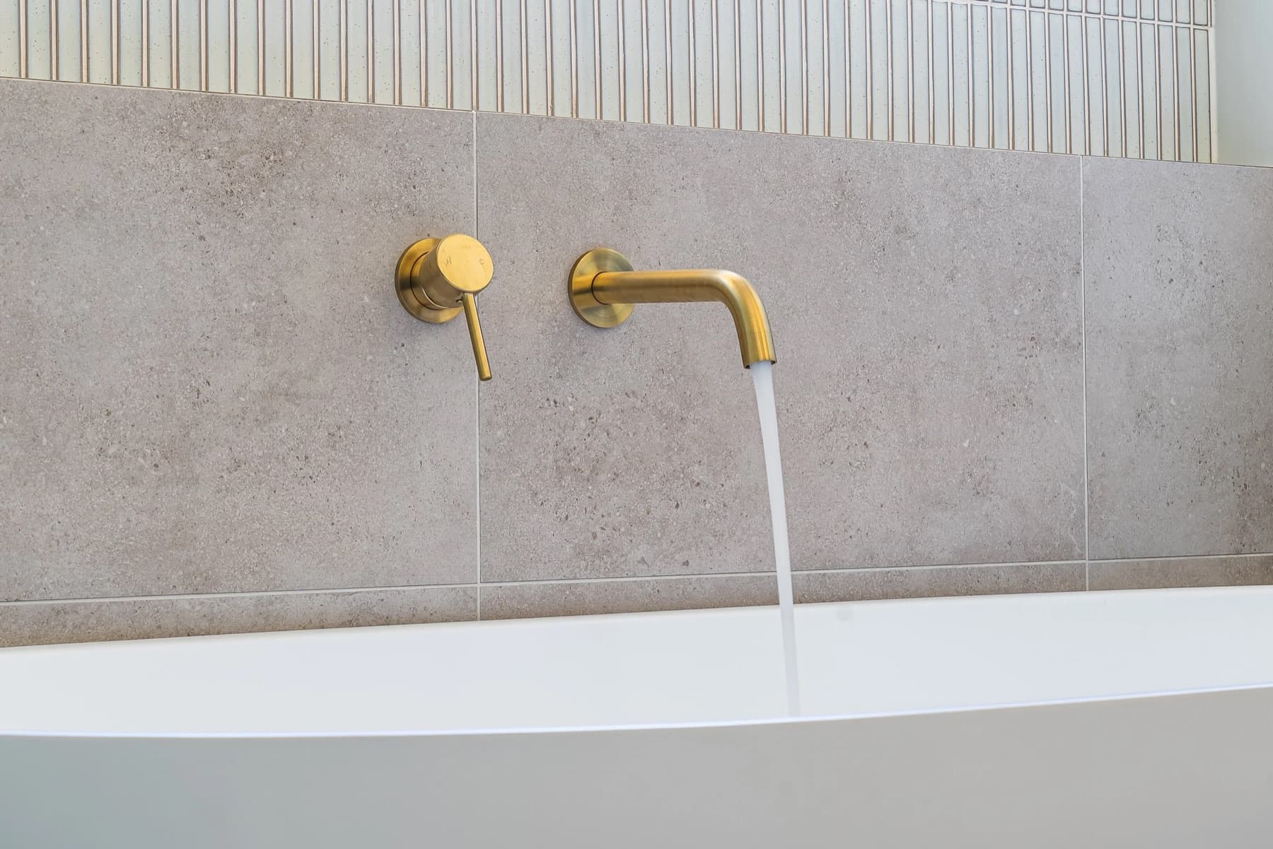 Renovated Tarragindi bathroom with brushed-gold tapware, freestanding tub and warm timber vanity.